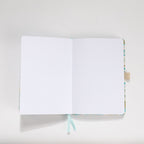 Open A5 journal showing the 160gsm dot grid interior pages with light blue ribbon bookmark