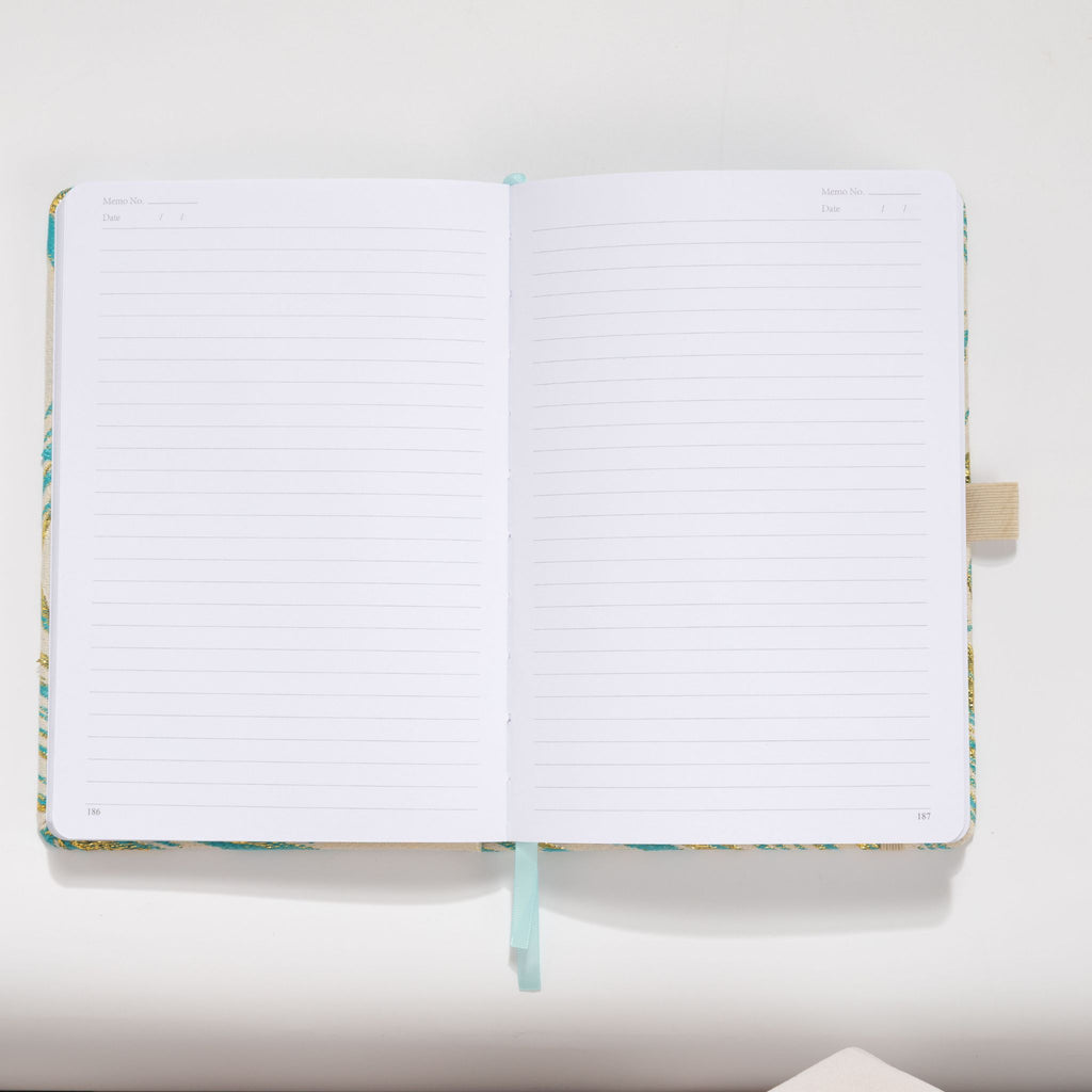 Open A5 journal showing the 100gsm lined paper interior with date and memo headers.