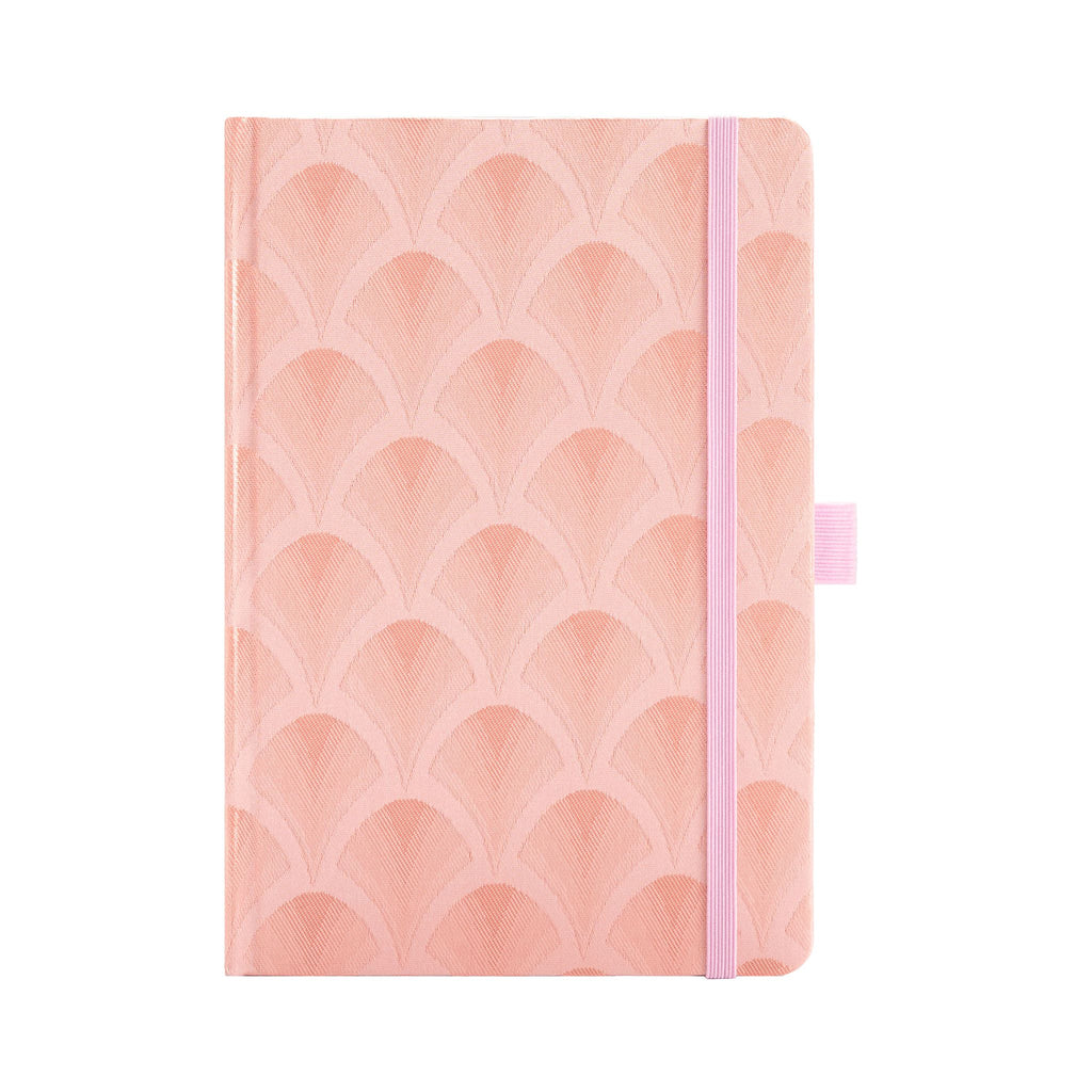 A5 pink woven fabric notebook with a scalloped embroidery pattern, standing upright on a white background with a matching pink 
