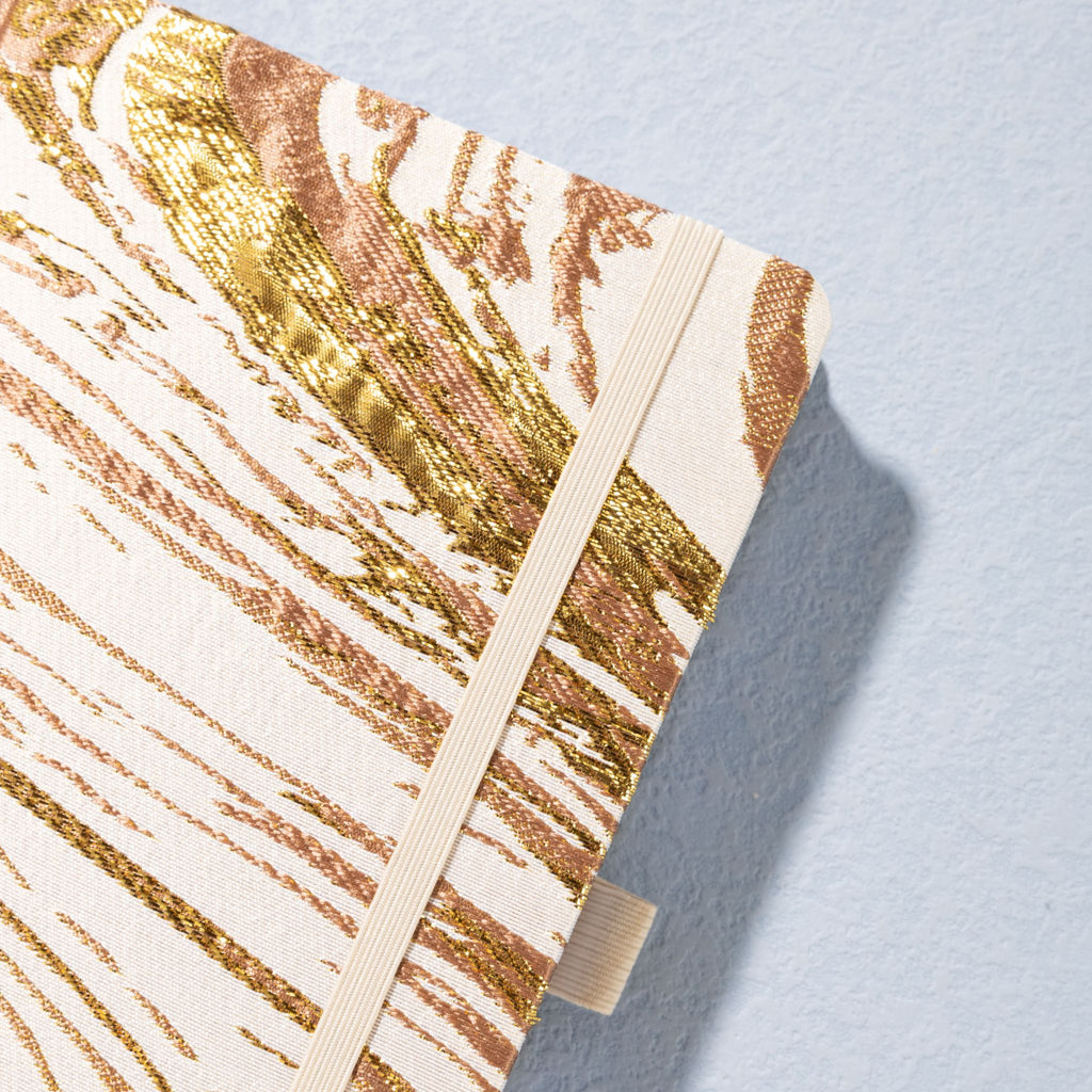 Close-up of gold marble metallic foil fabric cover texture