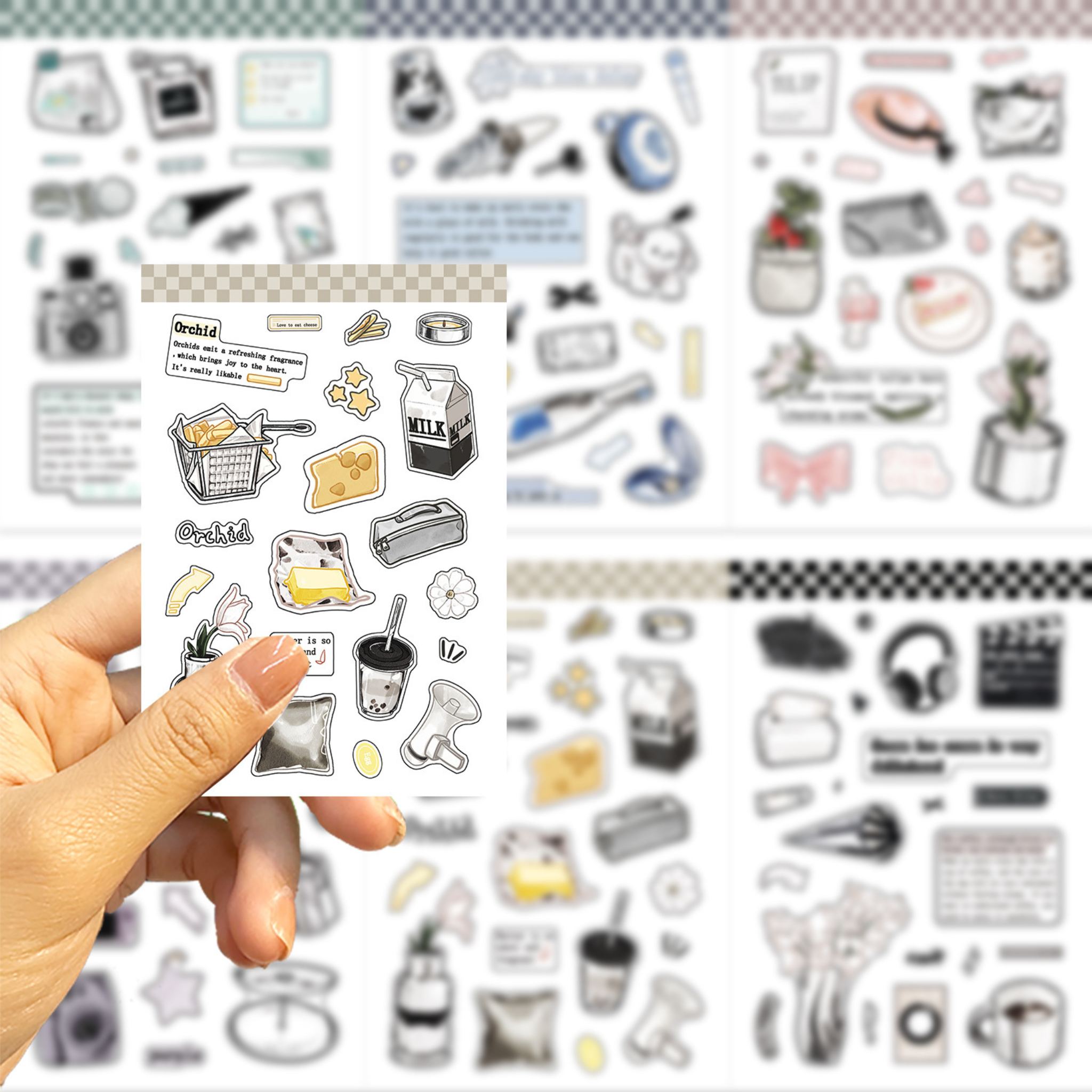 A hand holds a sheet of cute, food-themed planner stickers against a blurred background of matching sticker sheets. The stickers feature illustrations of cheese, milk, coffee, and snacks in a minimalist, hand-drawn style.