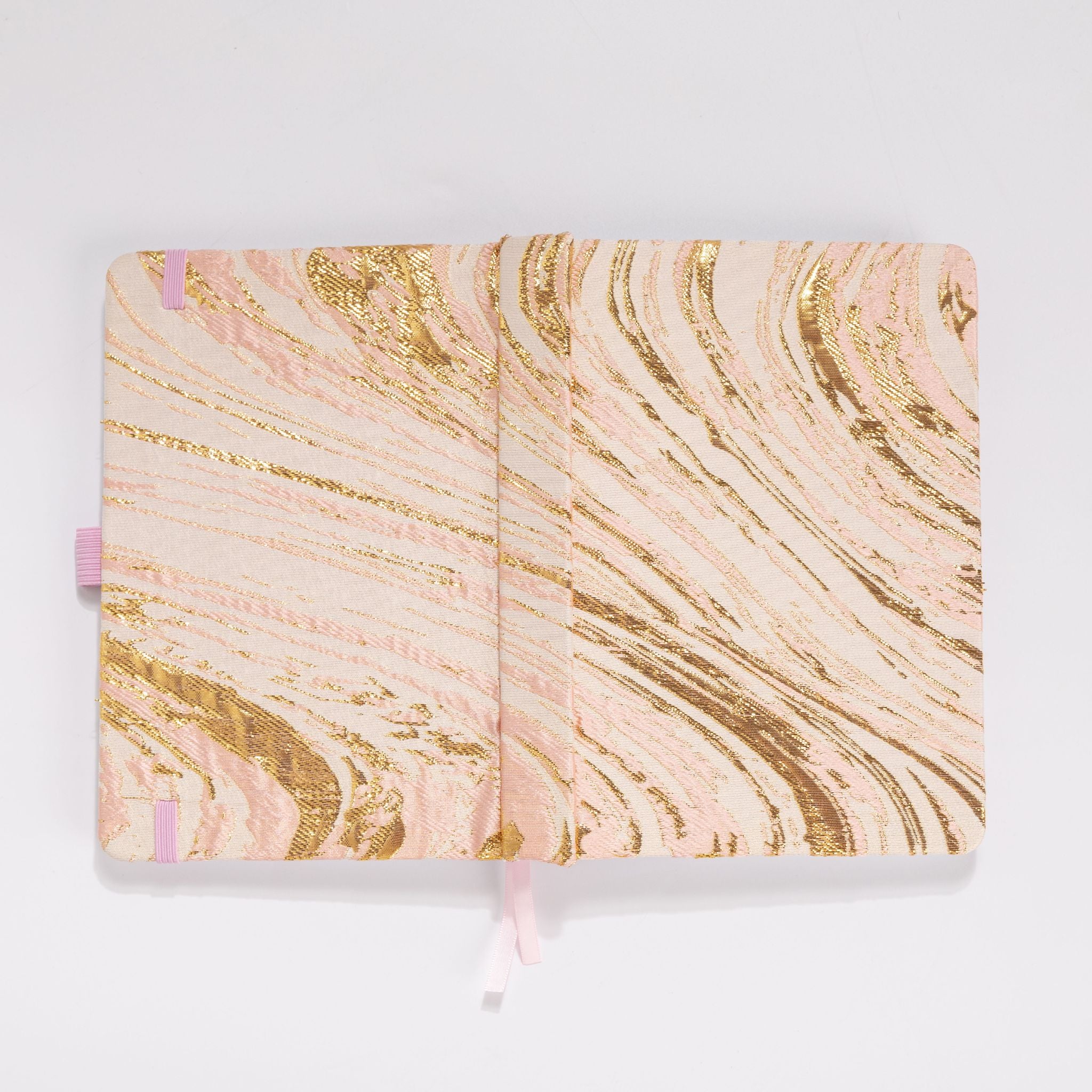 Flat lay of the blush pink and gold marble woven fabric cover opened completely