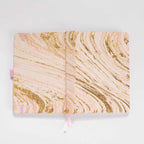 Flat lay of the blush pink and gold marble woven fabric cover opened completely