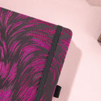 Close-up of the dark purple and black metallic woven fabric cover and matching black elastic strap.