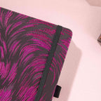 Close-up of the dark purple and black metallic woven fabric cover and matching black elastic strap.