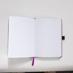 Open A5 notebook showing the 100gsm lined paper interior with date headers