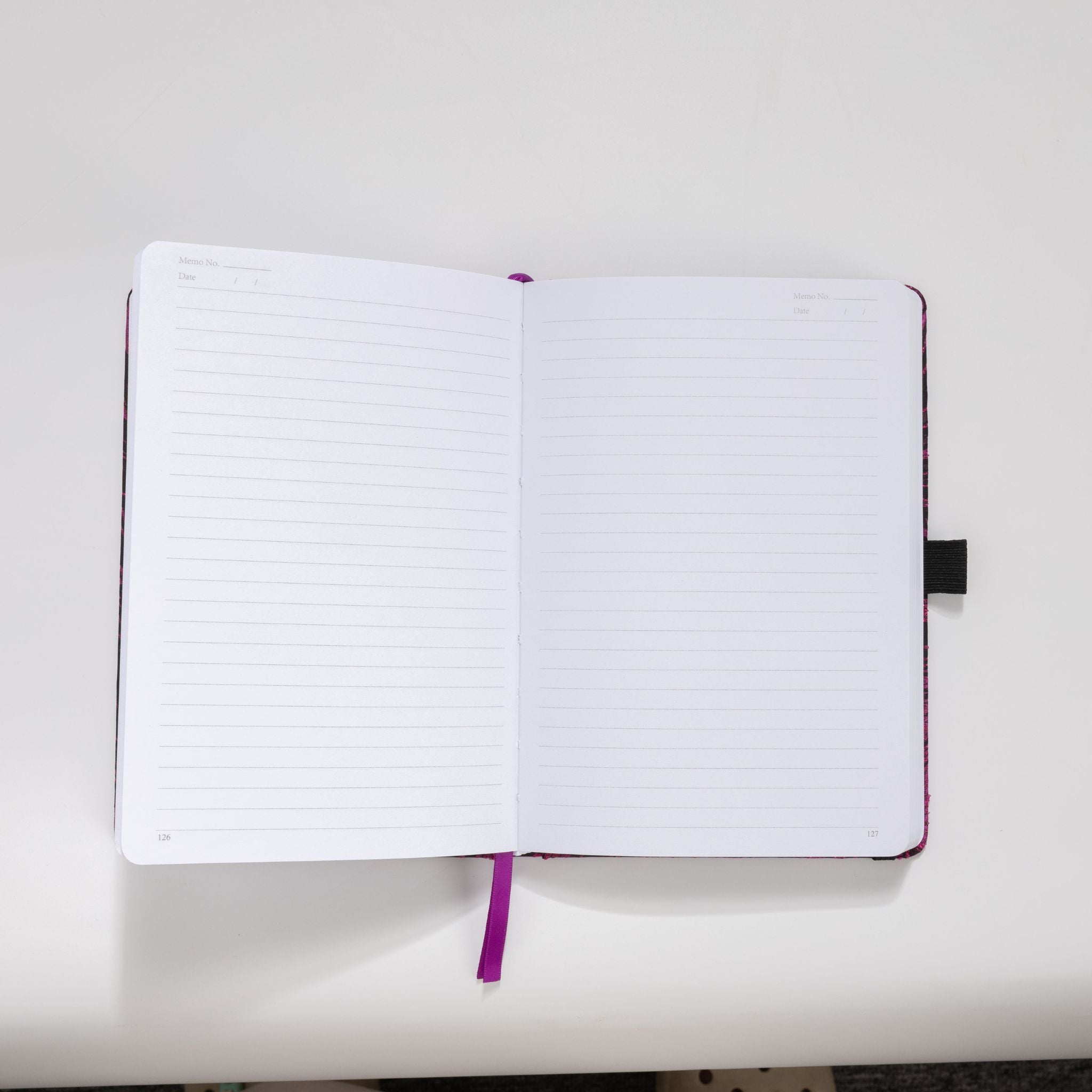 Open A5 notebook showing the 100gsm lined paper interior with date headers