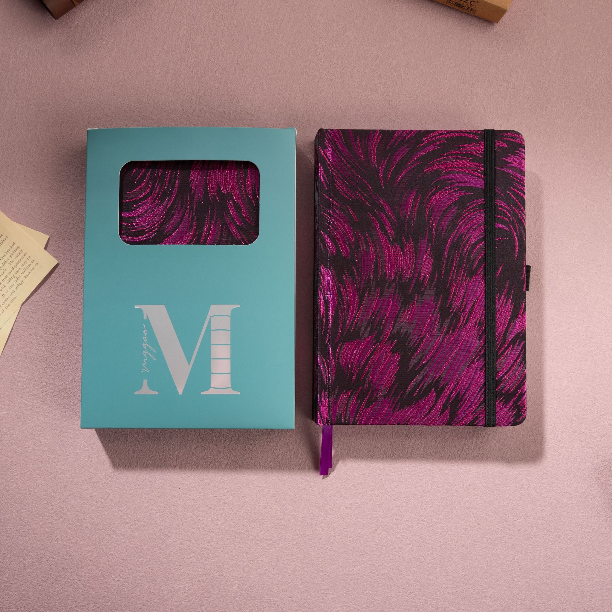 Purple metallic swirl fabric notebook placed next to its signature light blue window-cut gift box