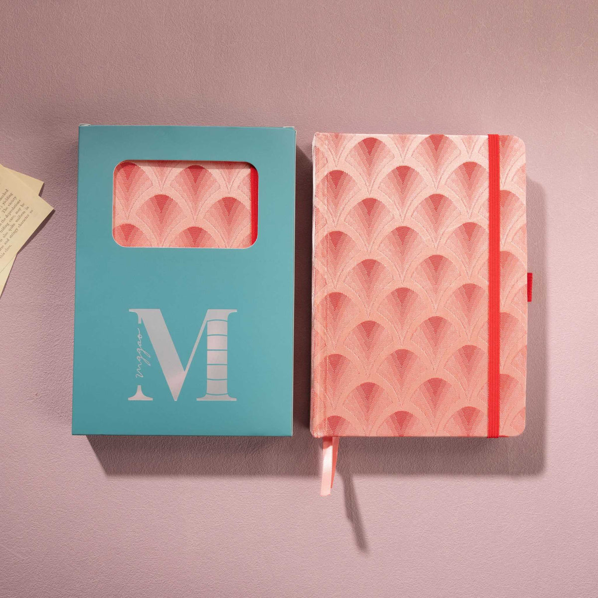 Red scalloped fabric notebook displayed next to its signature light blue window-cut gift box