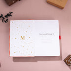 Inside title page with gold foil "M" logo and "This Journal Belongs To" section on a red scalloped notebook