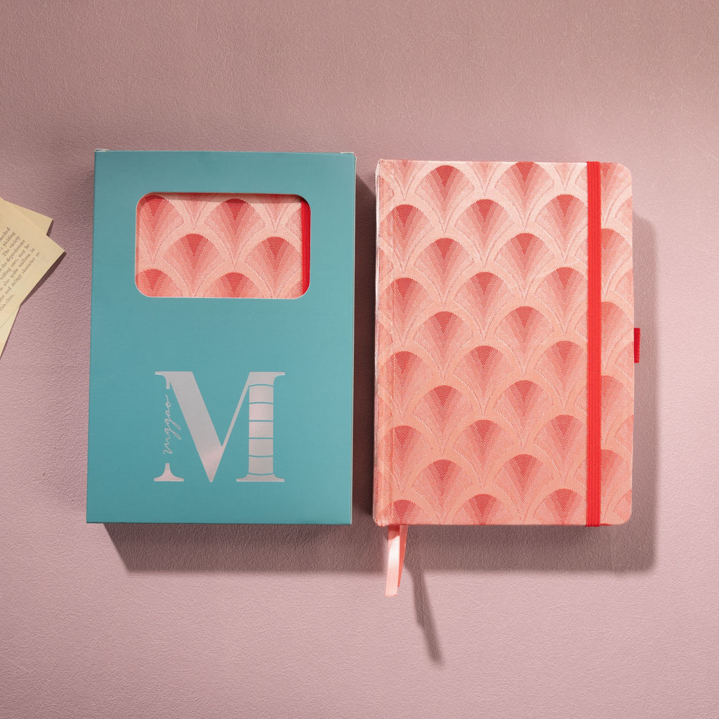 Red scalloped fabric notebook displayed next to its signature light blue window-cut gift box