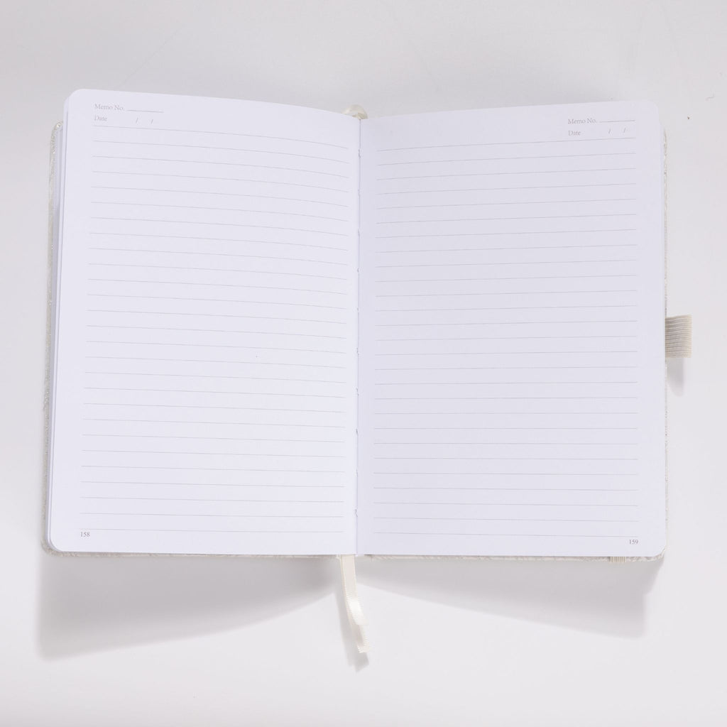 Open A5 notebook showing the 100gsm lined paper interior with date headers