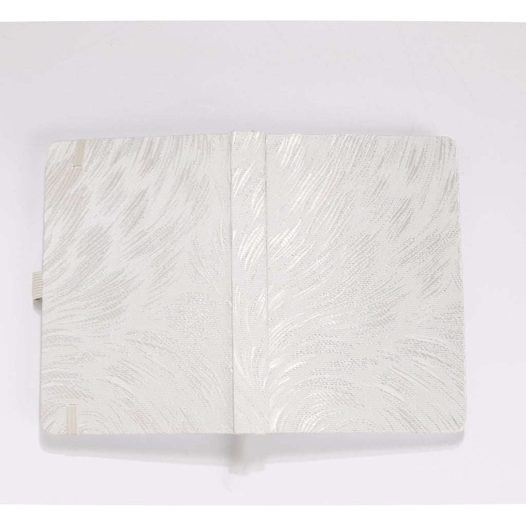 Flat lay of the white and silver embroidered fabric cover opened completely