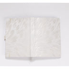 Flat lay of the white and silver embroidered fabric cover opened completely