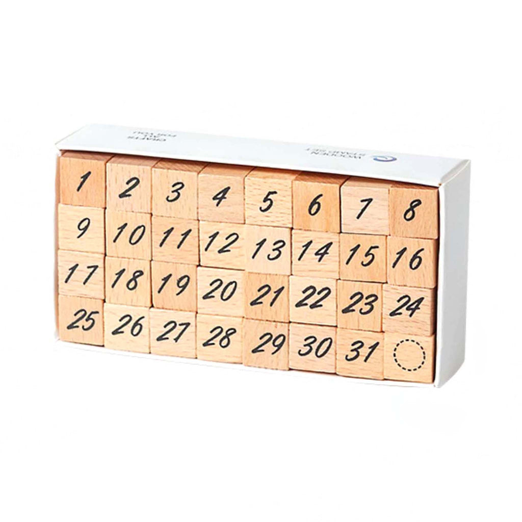 A white storage box containing 32 wooden number stamps arranged in four rows of eight, featuring numbers 1 through 31 and a circle marker, displayed on a clean white background.